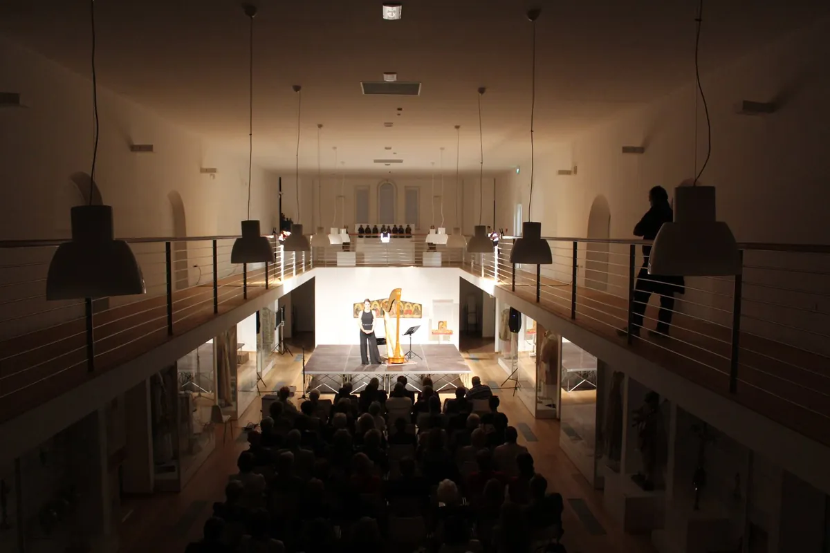 Eleonora Congiu in solo recital on a museum stage, seen from the balcony